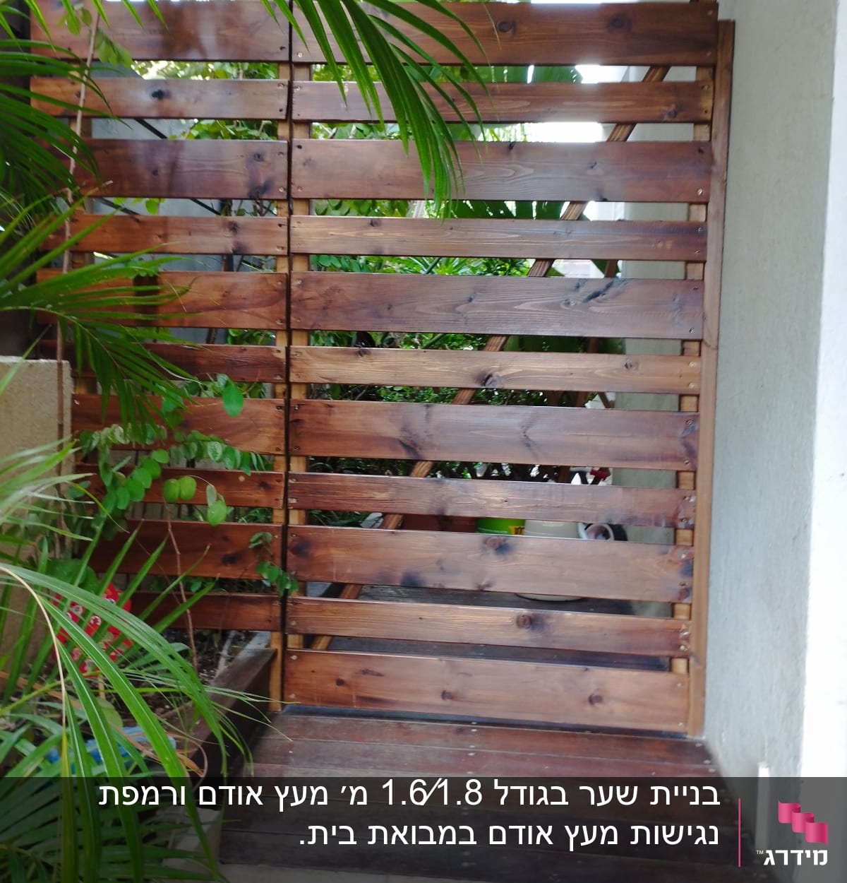 גדר עץ חומה עם צמחים ירוקים מסביב